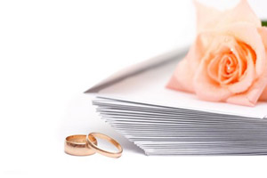 Rose, envelopes and wedding rings on a white background